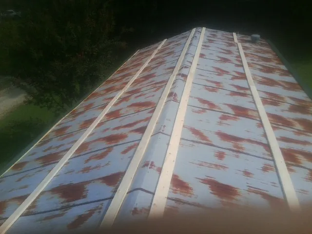 Rusted metal roof panels with new wood purlins before replacement — Storm Damage Roof Repair in South Otselic by Roofing Brothers