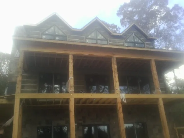 Dormers and porch framing on a large log home under construction — Roof Coating work by our crew in South Otselic